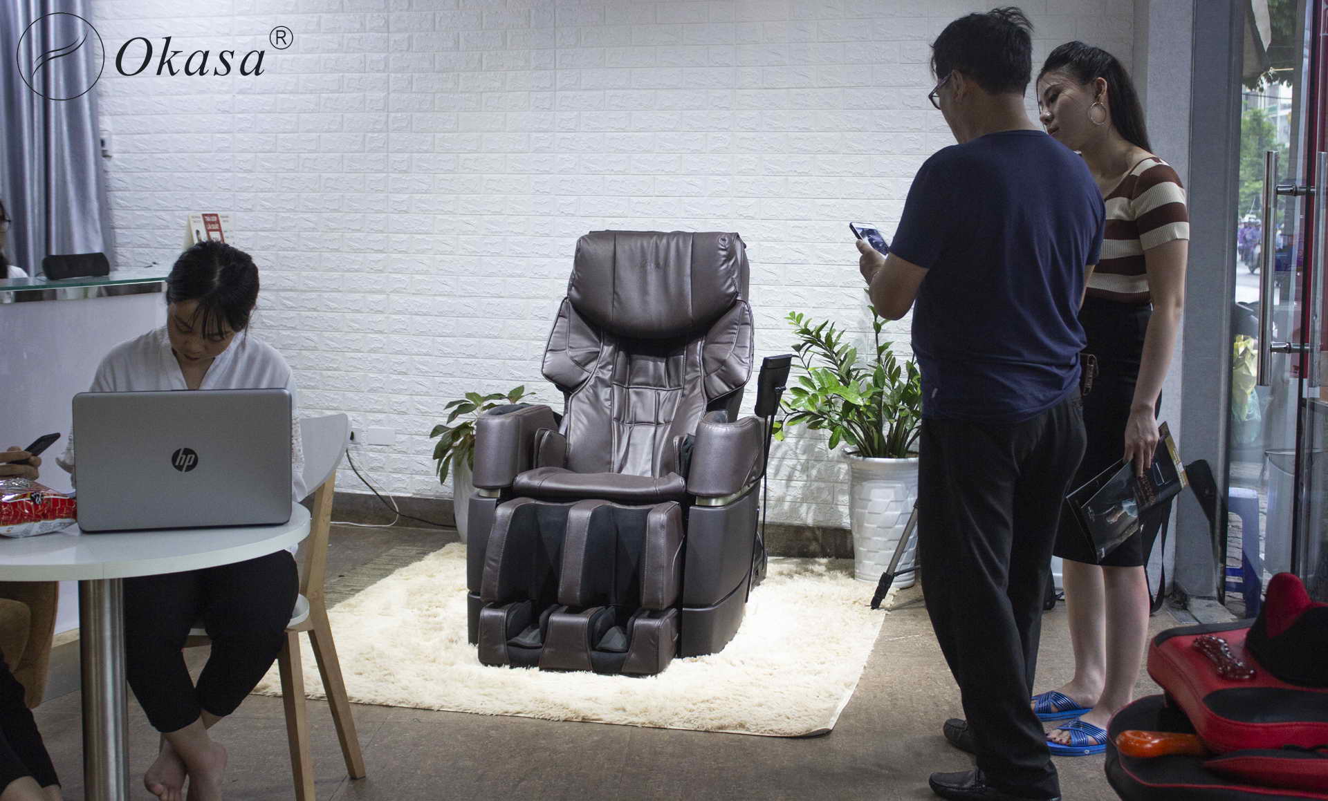 Khách hàng đang kiếm tra sản phẩm ghế massage toàn thân tại Okasa